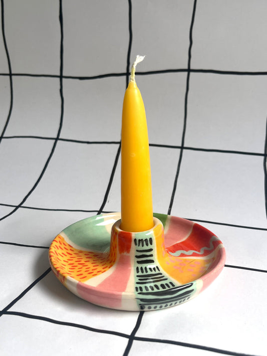 Ceramic candle holder decorated with patterns using underglazes. 