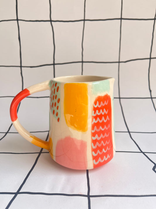 The other side of a colourful jug with a abstract patterns on a white background with black grid lines